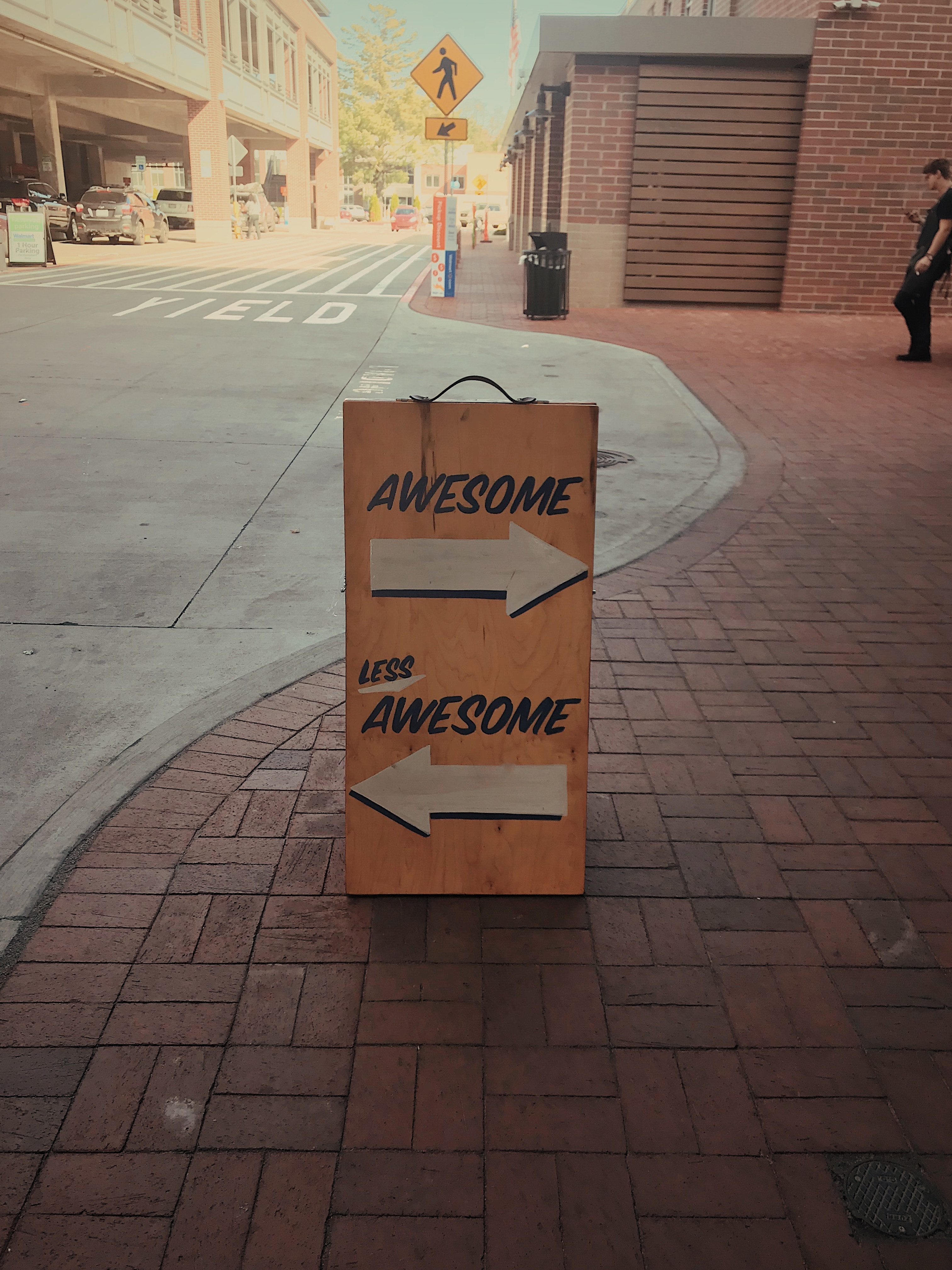 a sign that says awesome above a right pointing arrow, and less awesome above a left pointing arrow